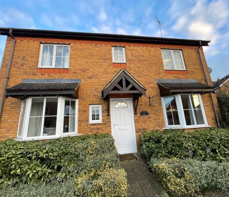 Brick house front with white windows and bay windows